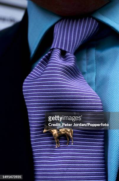 Racegoer wears a jockey and racehorse tie-pin in his tie as he watches horse racing at York Racecourse in York, North Yorkshire, England in 1997.