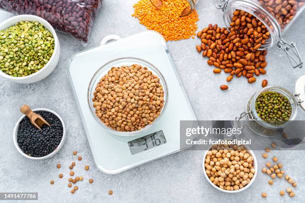 weighting dried legumes with kitchen scale - kitchen scale stock pictures, royalty-free photos & images