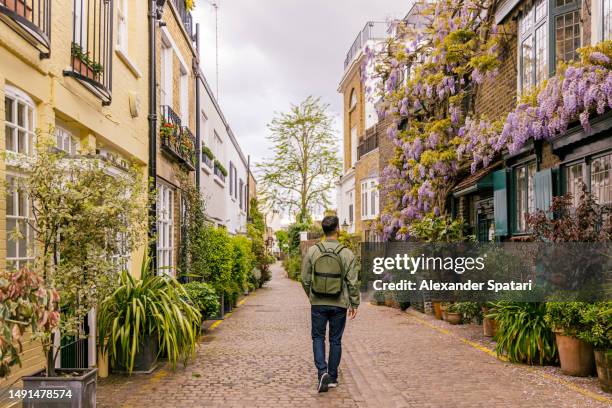 rear view of a man walking among mews houses in south kensington district, london, uk - kensington and chelsea stock pictures, royalty-free photos & images
