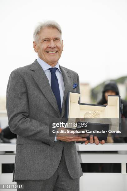 Harrison Ford shows the honorary Palme D'Or he received during the "Indiana Jones And The Dial Of Destiny" photocall at the 76th annual Cannes film...