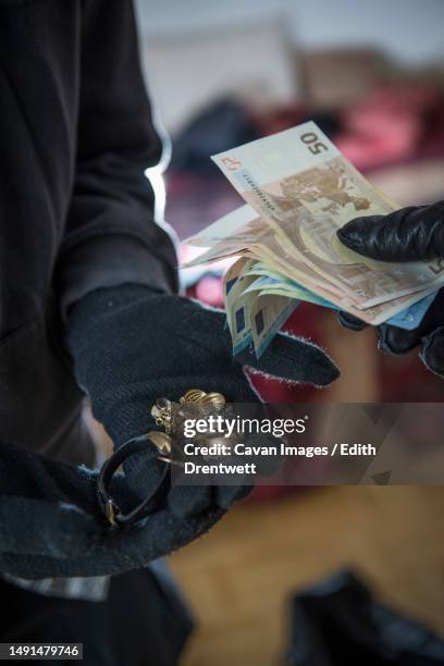 burglars stealing jewelry and euro banknotes - burglary stock pictures, royalty-free photos & images