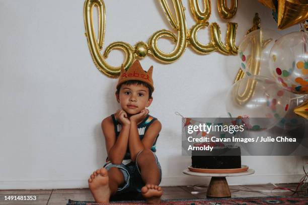 happy, young multiracial asian boy sitting with balloons and a c - mililani bildbanksfoton och bilder