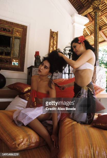 Dewi Sukarno, widow of Indonesia's founding president Sukarno, brushes her daughter Kartika's hair at their seaside lodgings in Bali on her first...