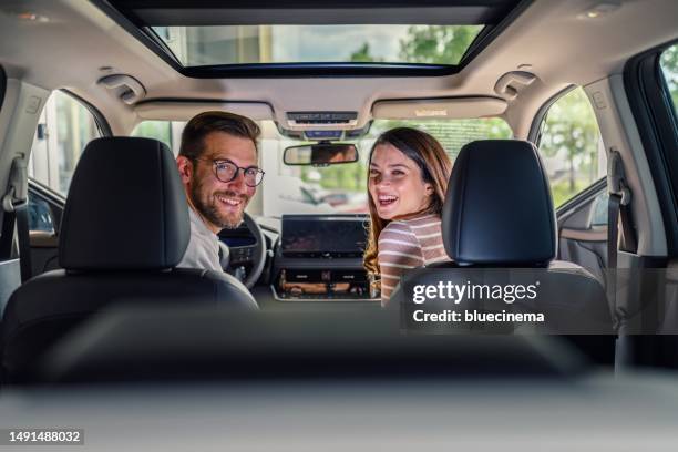 young happy couple sitting inside their new car - new best friend imagens e fotografias de stock