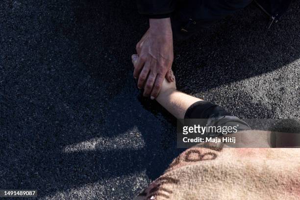 Climate activists from Last Generation , who have glued their hands to the asphalt on highway A100, hold their hands as they wait to be removed by...