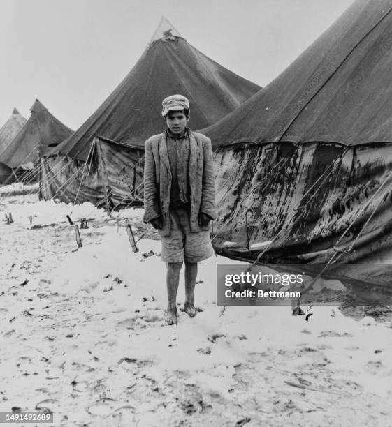 Jewish boy from Yemen stands barefoot in the snow at the Ras El Ayn immigrant reception camp in Israel, February 14th 1950. In early February, it...