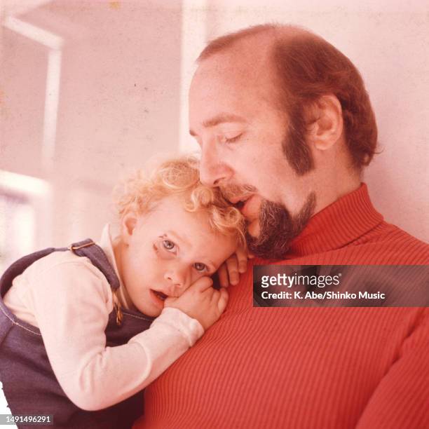Herbie Mann holds his daughter in his arm, at his apartment in New York City, United States, 26 October 1973