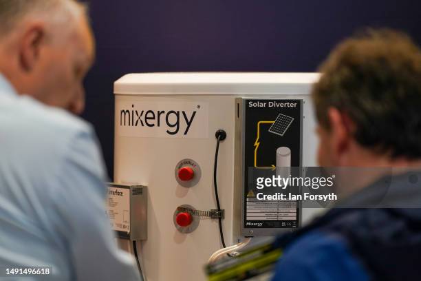 Two men discuss heat pumps at a stand during the Fully Charged live show at the Yorkshire Events Centre on May 19, 2023 in Harrogate, England. The...
