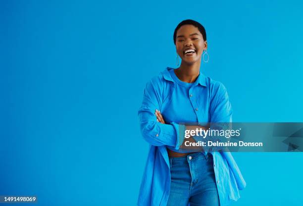 joven mujer negra de pie con los brazos cruzados, riendo mirando a la cámara con ropa casual con copia de la foto de archivo del espacio - colored clothes fotografías e imágenes de stock