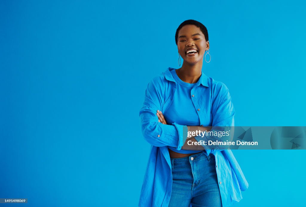 Giovane donna nera in piedi con le braccia incrociate, ridendo guardando la macchina fotografica che indossa abiti casual con foto stock di spazio copia