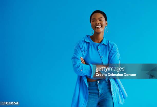 young black woman standing with her arms crossed, laughing looking at the camera wearing casual clothing with copy space stock photo - top garment stock pictures, royalty-free photos & images