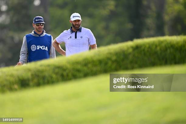 Dustin Johnson of the United States and his caddie Austin Johnson wait to play a shot on the 12th green during the second round of the 2023 PGA...