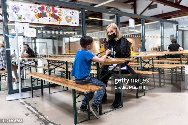 Olena chat with Maxim, refugee from Ukraine in dinning room at the temporary refugee shelter and welcome center at former Tegel airport on May 19,...