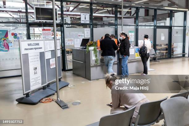 Refugees from Ukraine at the information desk at the temporary refugee shelter and welcome center at former Tegel airport on May 19, 2023 in Berlin,...