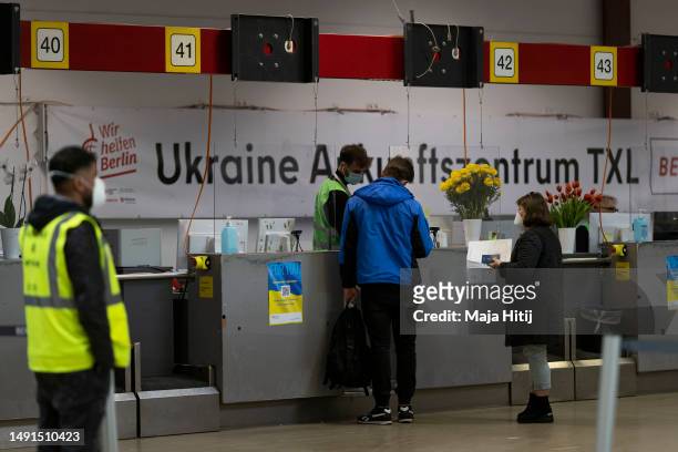 Refugees from Ukraine talk to workers at welcome center at former Tegel airport on May 19, 2023 in Berlin, Germany. Authorities are expecting...