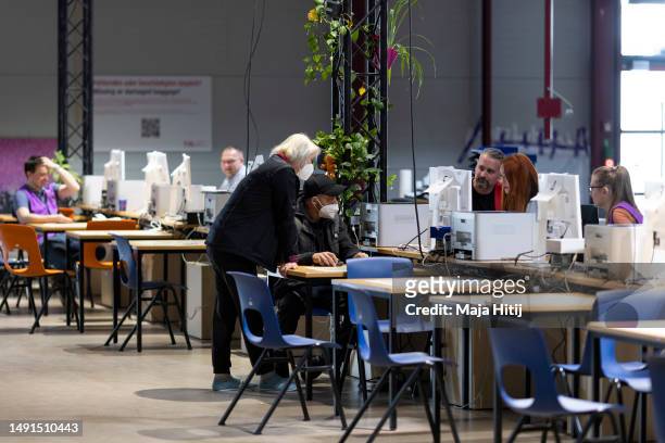Refugees from Ukraine talk to workers at the welcome center at former Tegel airport on May 19, 2023 in Berlin, Germany. Authorities are expecting...