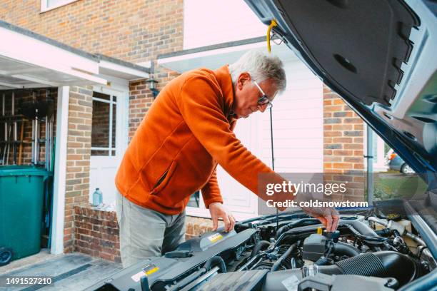 man checking the engine of his car at home - dipstick stock pictures, royalty-free photos & images