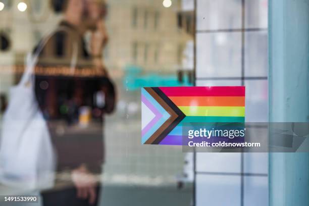 equal opportunities employer with lgbt flag in window - rainbow flag stock pictures, royalty-free photos & images