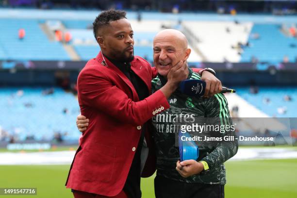 Antonio Pintus, conditioning coach of Real Madrid, is embraced by Patrice Evra during the UEFA Champions League semi-final second leg match between...