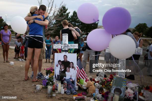 Movie-theater-shooting-victim Gordon Cowden's family gather at the makeshift memorial built across the street from the Century 16 theater July 23,...