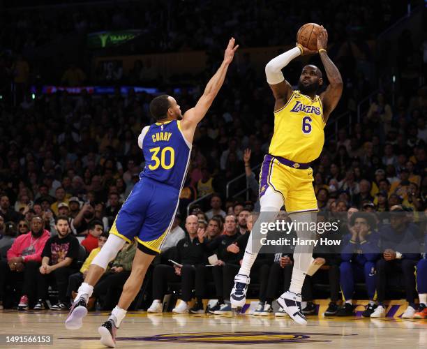 LeBron James of the Los Angeles Lakers shoots a jumper over Stephen Curry of the Golden State Warriors in game six of the Western Conference...