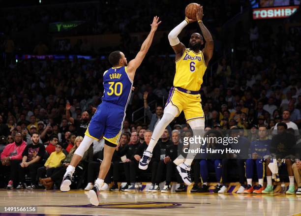 LeBron James of the Los Angeles Lakers shoots a jumper over Stephen Curry of the Golden State Warriors in game six of the Western Conference...