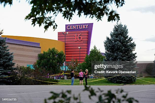 People stand in the parking lot outside the Century 16 movie theater where 12 people were killed in a shooting rampage last Friday, on July 23, 2012...