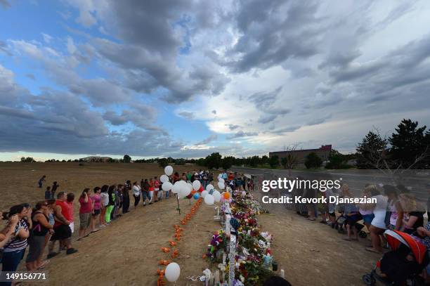 Thousands of people continue to visit the makeshift memorial for the 12 movie theater shooting victims built across the street from the Century 16...