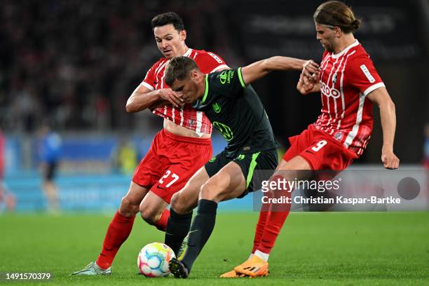 Nicolas Hofler and Lucas Holer of SC Freiburg battles for the ball with Micky van de Ven of Wolfsburg during the Bundesliga match between Sport-Club...