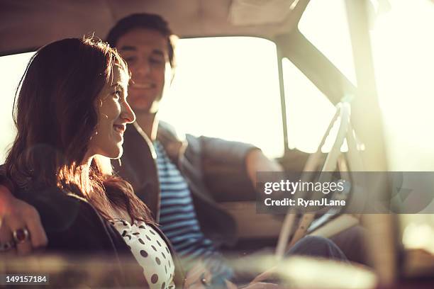 auto paar bei sonnenuntergang - fahrspaß stock-fotos und bilder