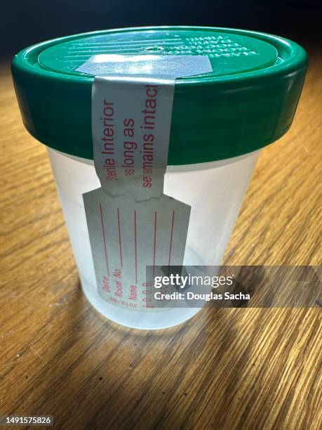 empty urine cup for employee drug testing - urine cup stock pictures, royalty-free photos & images