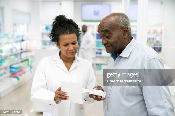 pharmacist helping senior customer - pharmacist explaining stock pictures, royalty-free photos & images