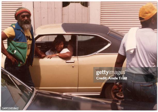 Lead drummer Steve Nisbett member of the English roots reggae band Steel Pulse, standing by a car with an event attendee in the car during the St....