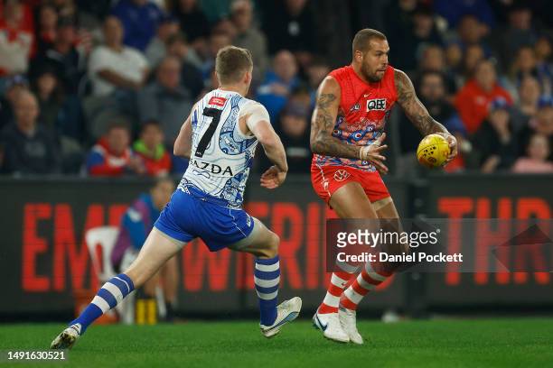 Lance Franklin of the Swans runs with the ball under pressure from Jack Ziebell of the Kangaroos during the round 10 AFL match between North...