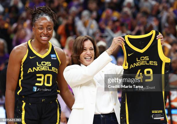 Vice President Kamala Harris receives a game jersey from Los Angeles Sparks forward Nneka Ogwumike before their game against the Phoenix Mercury at...