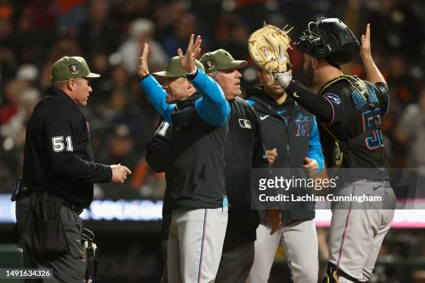 Manager Skip Schumaker and catcher Jacob Stallings of the Miami Marlins argue with umpires Marvin Hudson and Hunter Wendelstedt in the bottom of the...