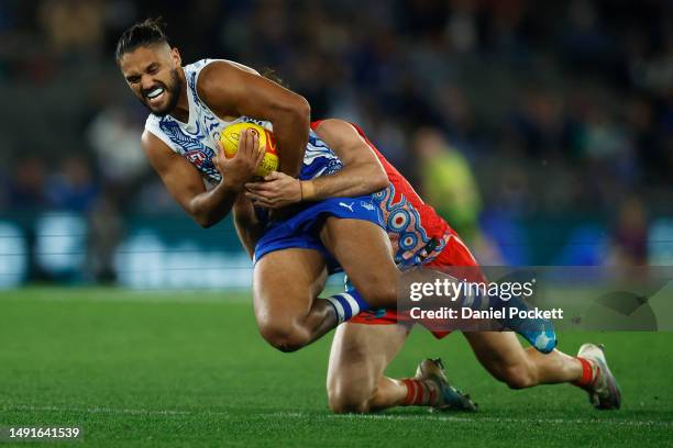 Aaron Hall of the Kangaroos is tackled by Errol Gulden of the Swans during the round 10 AFL match between North Melbourne Kangaroos and Sydney Swans...