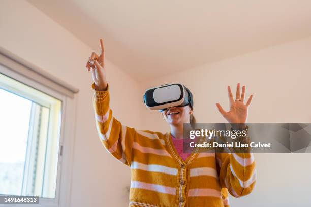 woman having fun while experiencing virtual reality video games with vr glasses. - casa calvet stock pictures, royalty-free photos & images