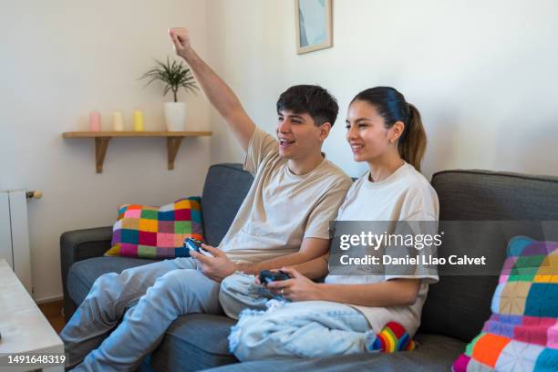 young couple having fun playing video games at home. - casa calvet stock pictures, royalty-free photos & images