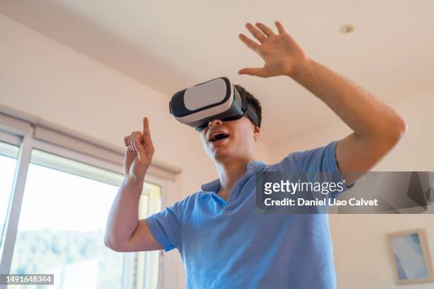 man having fun while experiencing virtual reality with vr glasses. - casa calvet stock pictures, royalty-free photos & images