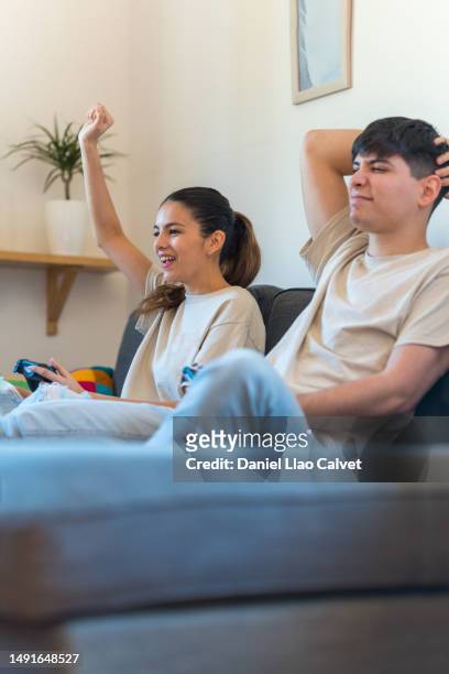 woman celebrating winning her boyfriend at video games. - casa calvet stock pictures, royalty-free photos & images