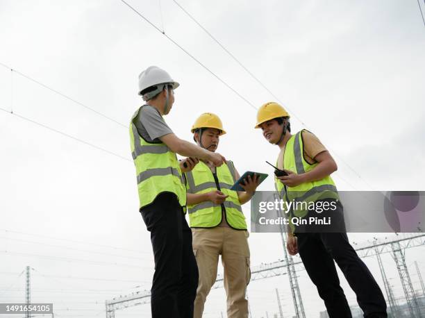 technicians are using tablets to look at the trouble spots - safety pin stockfoto's en -beelden