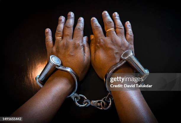 human hand with indian handcuffs - david law - fotografias e filmes do acervo