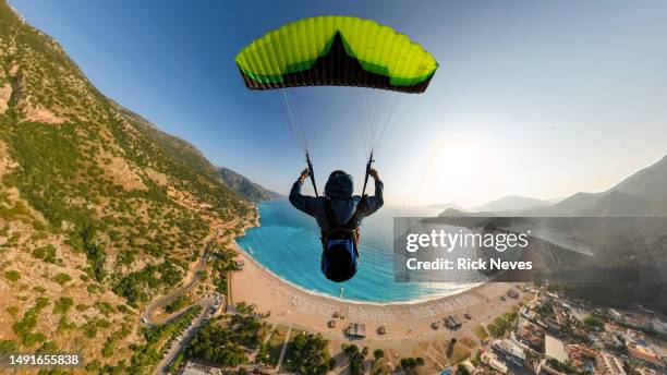 extreme paraglider pilot flying over the beach - ölüdeniz stock pictures, royalty-free photos & images