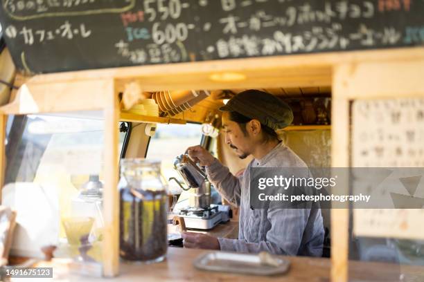 a man making coffee in his mobile coffee van parked outdoors - iwate prefecture stock pictures, royalty-free photos & images