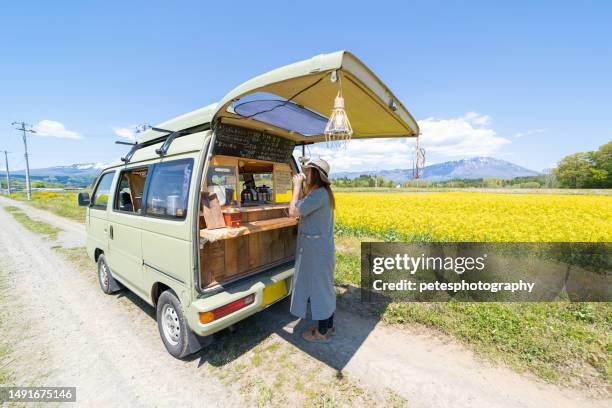 a woman buys coffee from a small business mobile coffee van in the countryside - iwate prefecture stock pictures, royalty-free photos & images