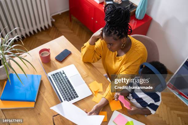 young black mother working from home with her son - 21 years later what peace stock pictures, royalty-free photos & images