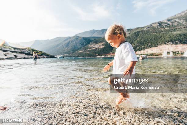 little boy having fun in the sea. - beach football stock pictures, royalty-free photos & images