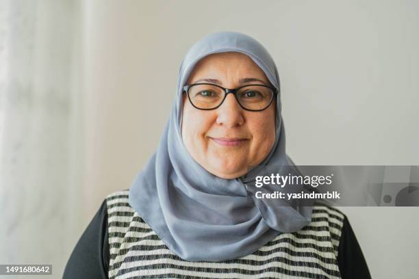 portrait of smiling middle aged woman in turban wearing glasses - veil isolated stock pictures, royalty-free photos & images