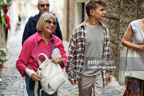 multi generation family walking in a charming, narrow street of tropea - boys and girls town stockfoto's en -beelden